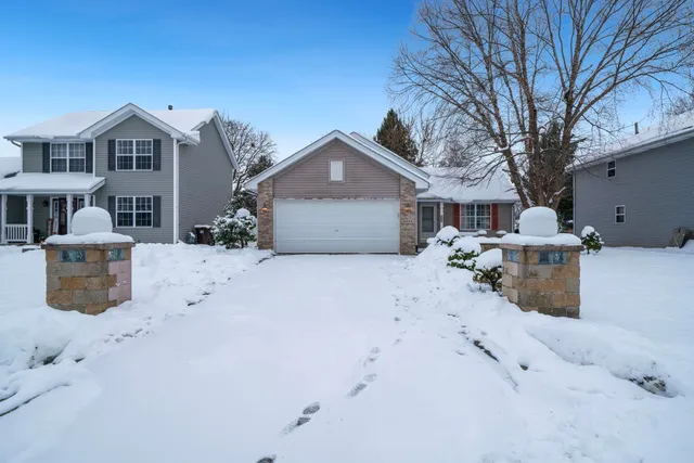 a front view of a house with a yard covered in snow