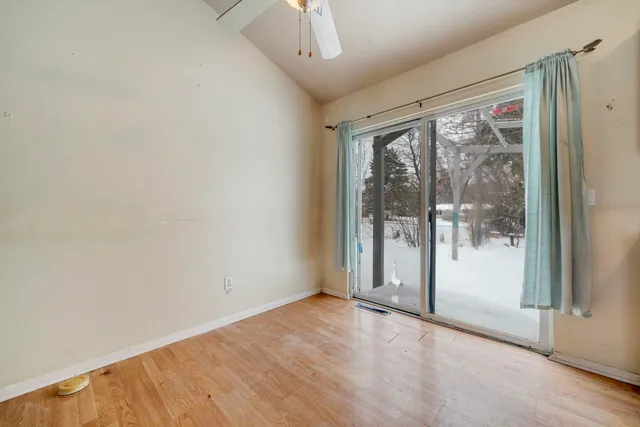 an empty room with wooden floor and windows