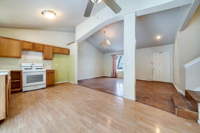 a view of kitchen with stainless steel appliances granite countertop a stove top oven a sink and a refrigerator