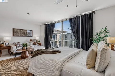 a bedroom with a bed couch and a large window