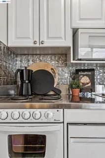 a kitchen with a stove and white cabinets