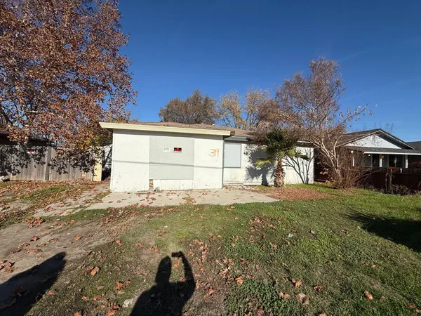 a view of a house with backyard and a tree