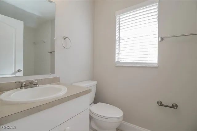 a bathroom with a sink a toilet and a window