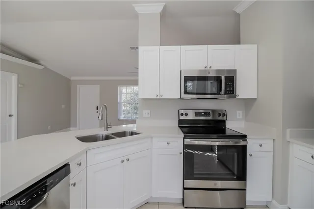a kitchen with appliances a sink and cabinets