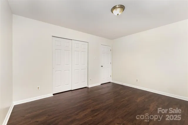 an empty room with wooden floor and natural light