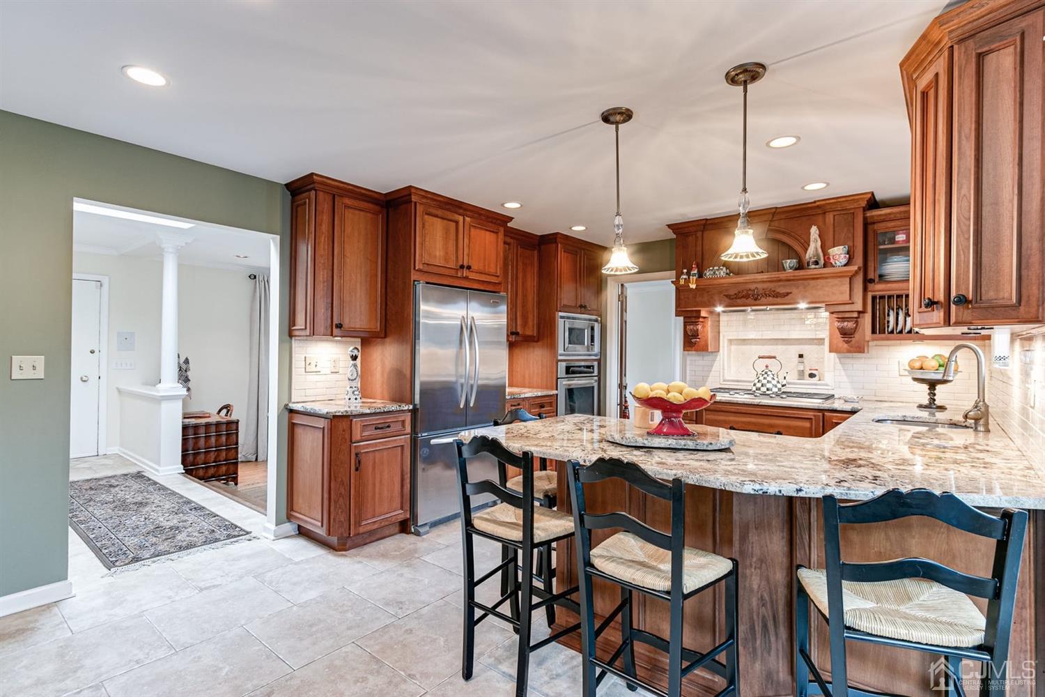 4 Moraine Road Edison, NJ 08820 - Photo 16 of 57 a kitchen with stainless steel appliances kitchen island granite countertop a table chairs and a refrigerator