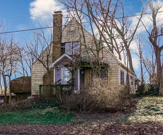 a front view of a house with yard and trees