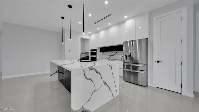 a kitchen with a refrigerator a stove and kitchen island