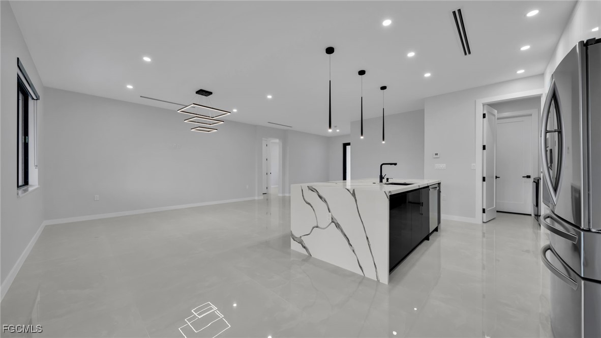 910 Northwest 36th Place Cape Coral, FL 33993 - Photo 12 of 46 a view of a kitchen with a sink and a refrigerator