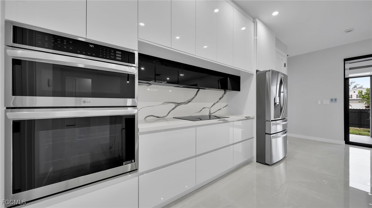 910 Northwest 36th Place Cape Coral, FL 33993 - Photo 15 of 46 a kitchen with stainless steel appliances kitchen island granite countertop a stove and a microwave