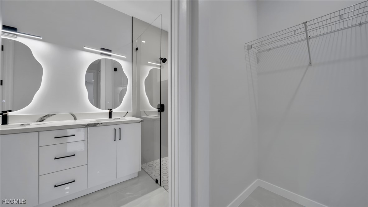 910 Northwest 36th Place Cape Coral, FL 33993 - Photo 22 of 46 a bathroom with double vanity sink and mirror