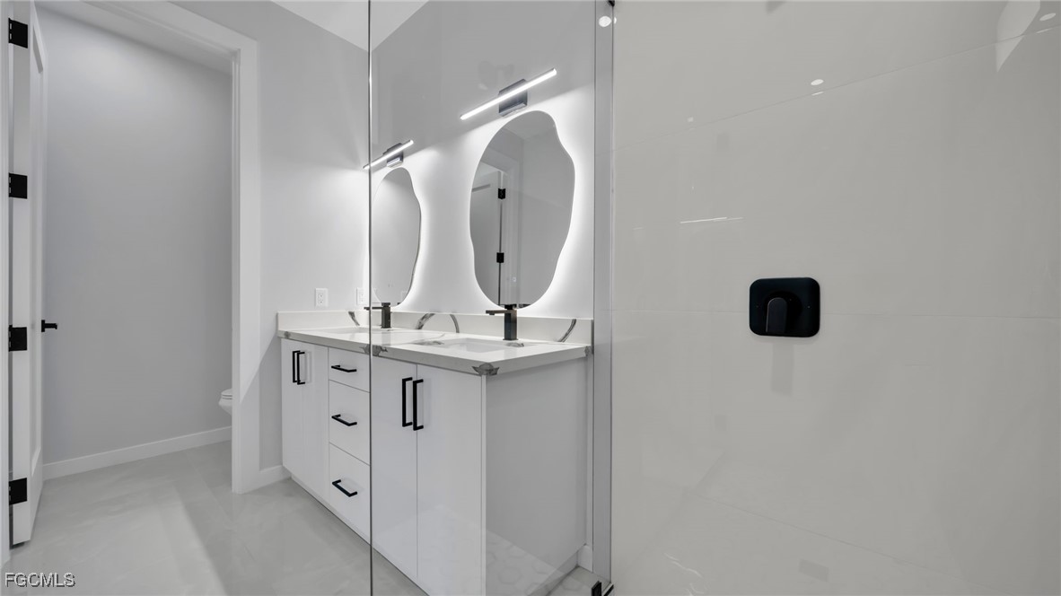 910 Northwest 36th Place Cape Coral, FL 33993 - Photo 25 of 46 a bathroom with a double vanity sink and mirror