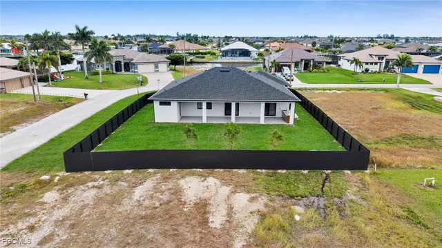an aerial view of a house with a garden and lake view