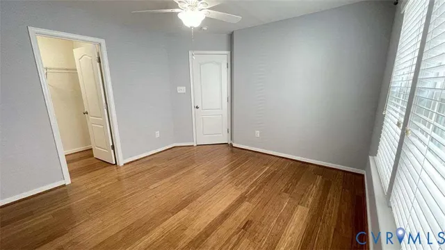 an empty room with wooden floor and windows
