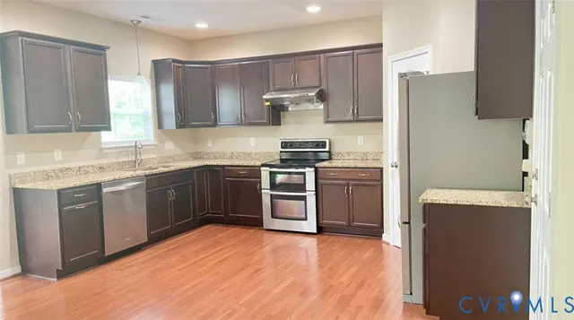 a kitchen with stainless steel appliances granite countertop a stove a sink dishwasher and a refrigerator