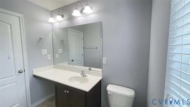 a bathroom with a toilet a sink a mirror and vanity