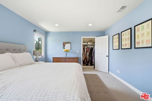 a bedroom with a bed and a large mirror