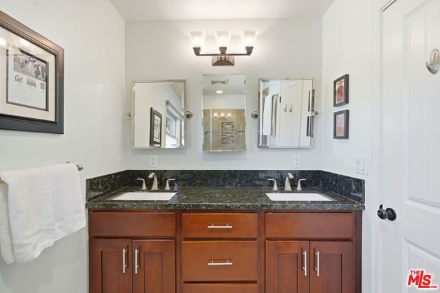 a bathroom with a granite countertop sink and a mirror