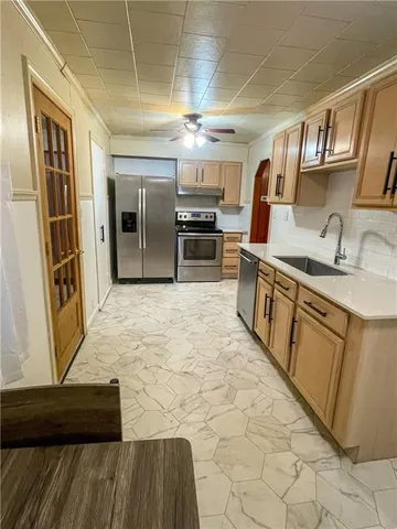 a large kitchen with stainless steel appliances granite countertop a sink and cabinets