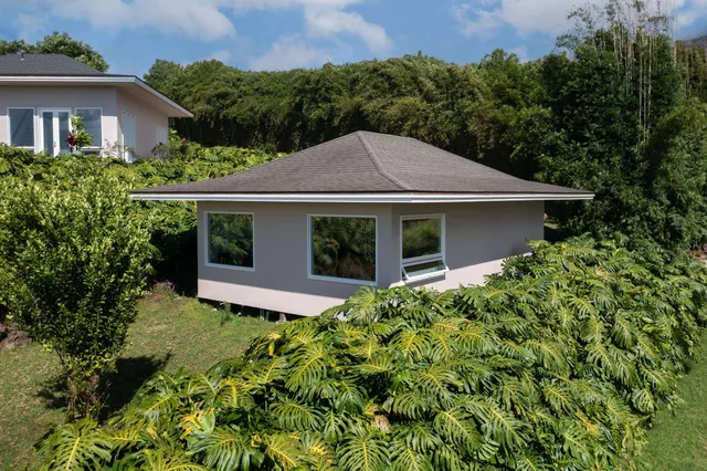 a white house with a yard and plants