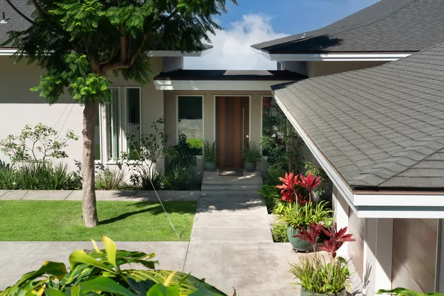 a front view of house with a garden