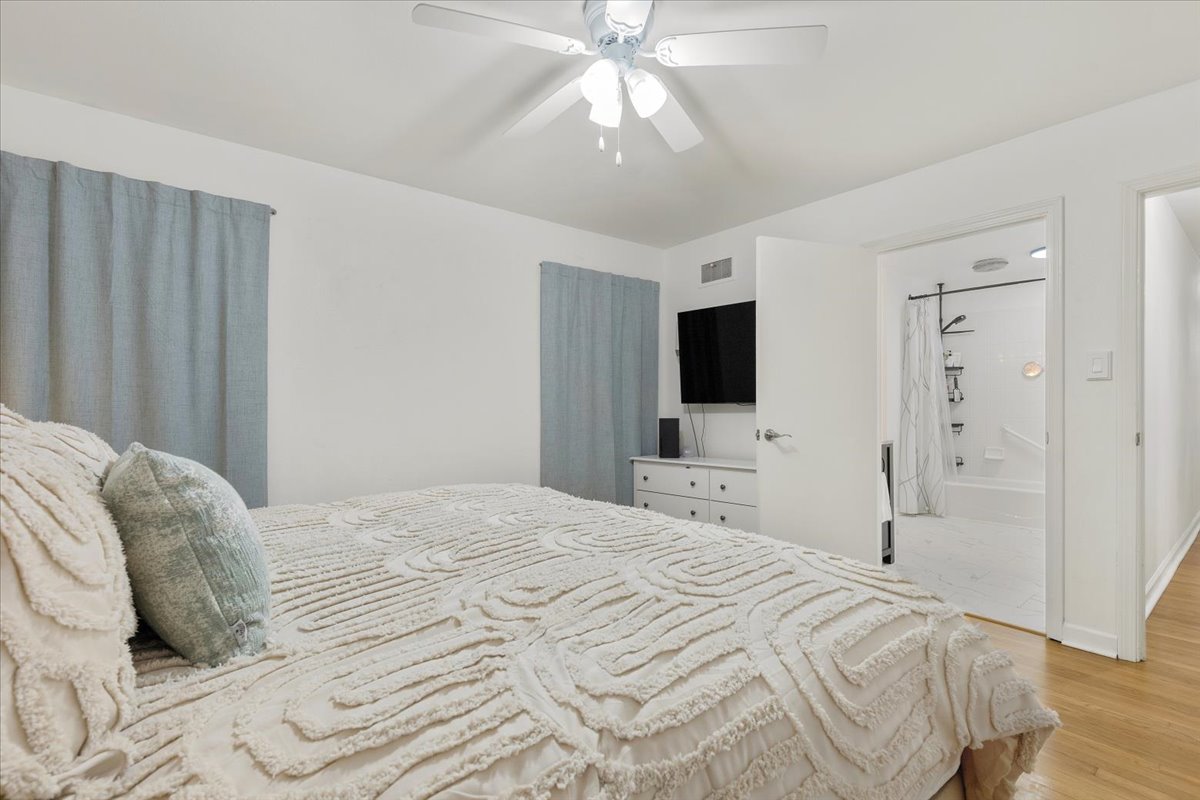 607 Short Street Smithville, TX 78957 - Photo 13 of 31 White-painted interior room with wood-finish flooring, a ceiling fan with integrated lighting, and light blue window treatments