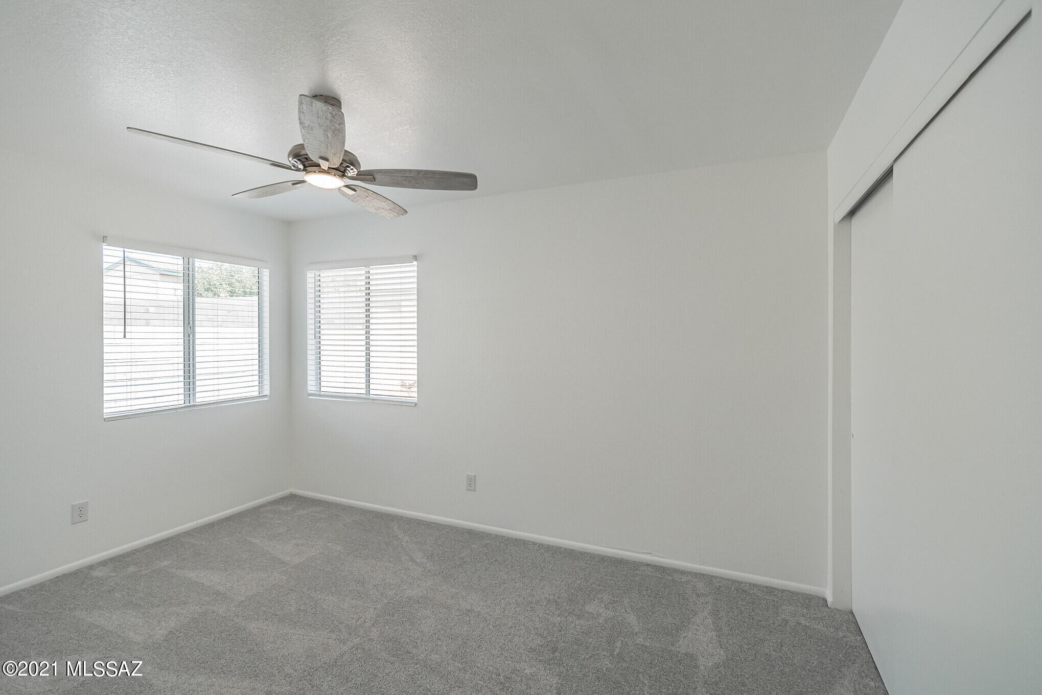 9671 East Azuma Way Tucson, AZ 85747 - Photo 20 of 31 an empty room with a window and a fan