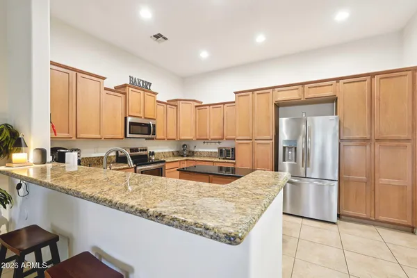 a kitchen with stainless steel appliances granite countertop a refrigerator a sink and a stove