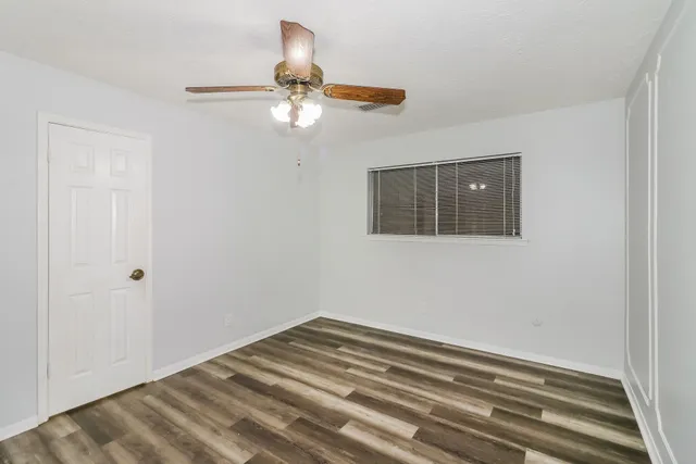 a bedroom with a bed and a chandelier fan