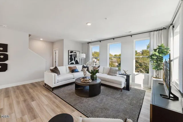 a living room with furniture a flat screen tv and a potted plant