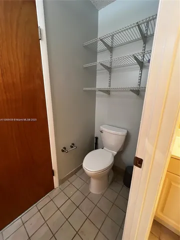 a white toilet sitting next to a shower