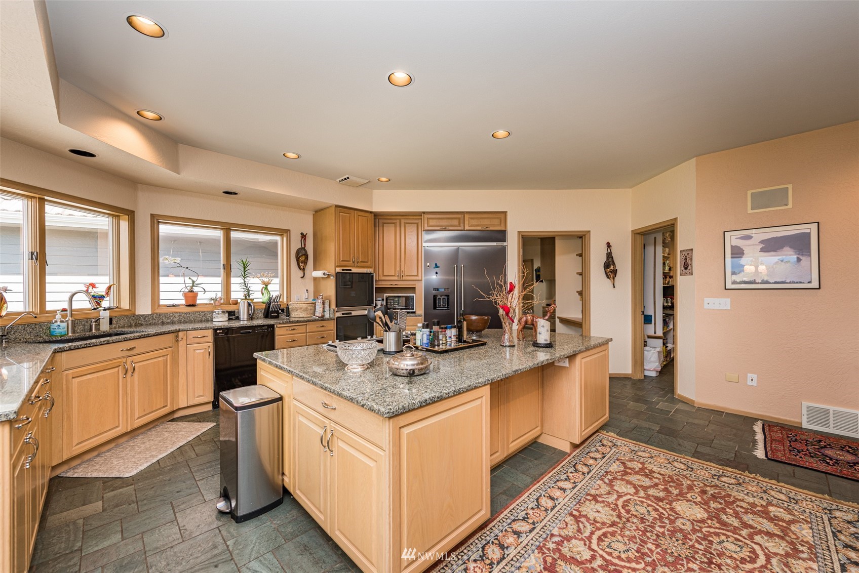 4949 Woodcock Road Sequim, WA 98382 - Photo 15 of 40 a large kitchen with kitchen island a sink counter space and stainless steel appliances