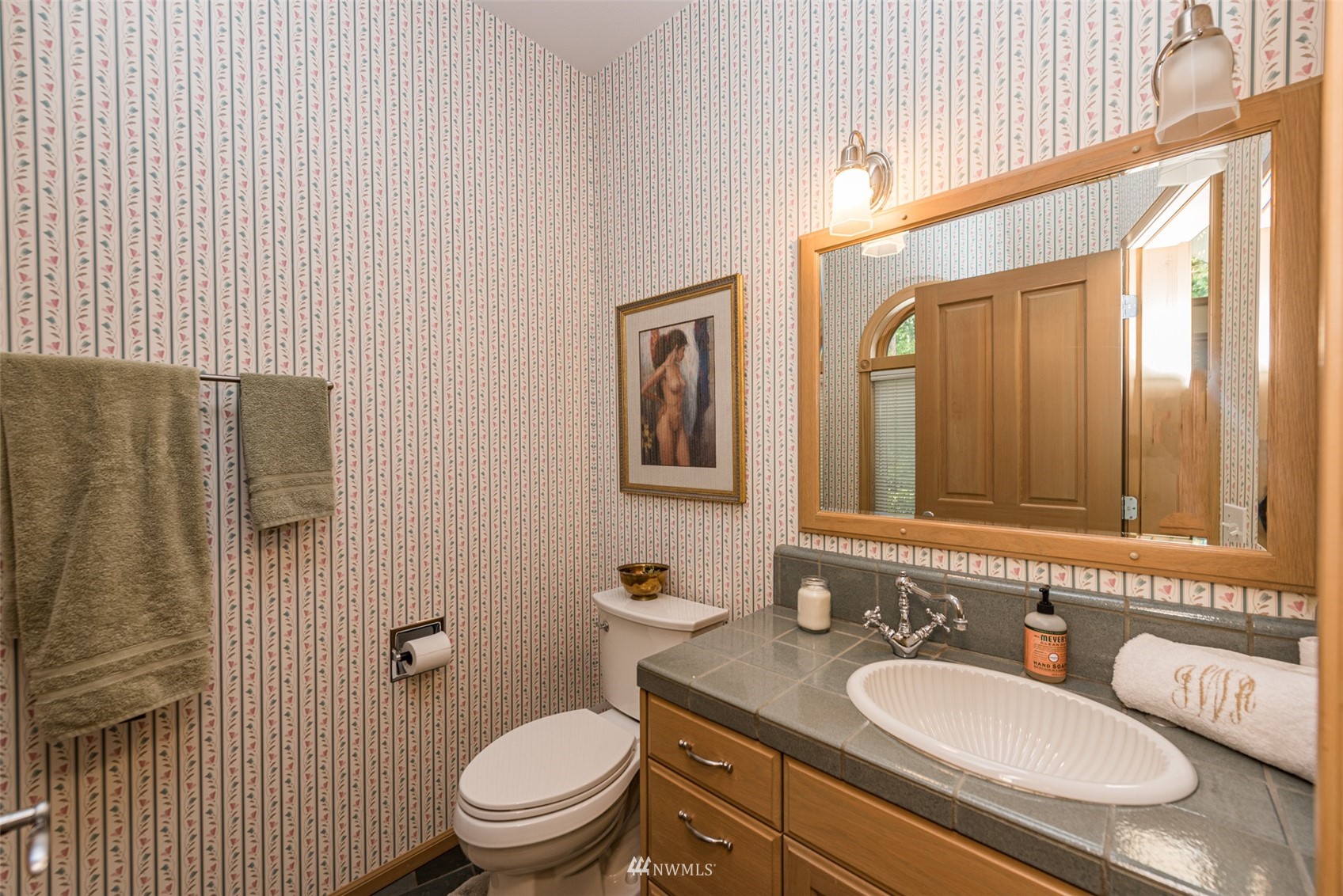 4949 Woodcock Road Sequim, WA 98382 - Photo 22 of 40 a bathroom with a granite countertop toilet a sink and a mirror