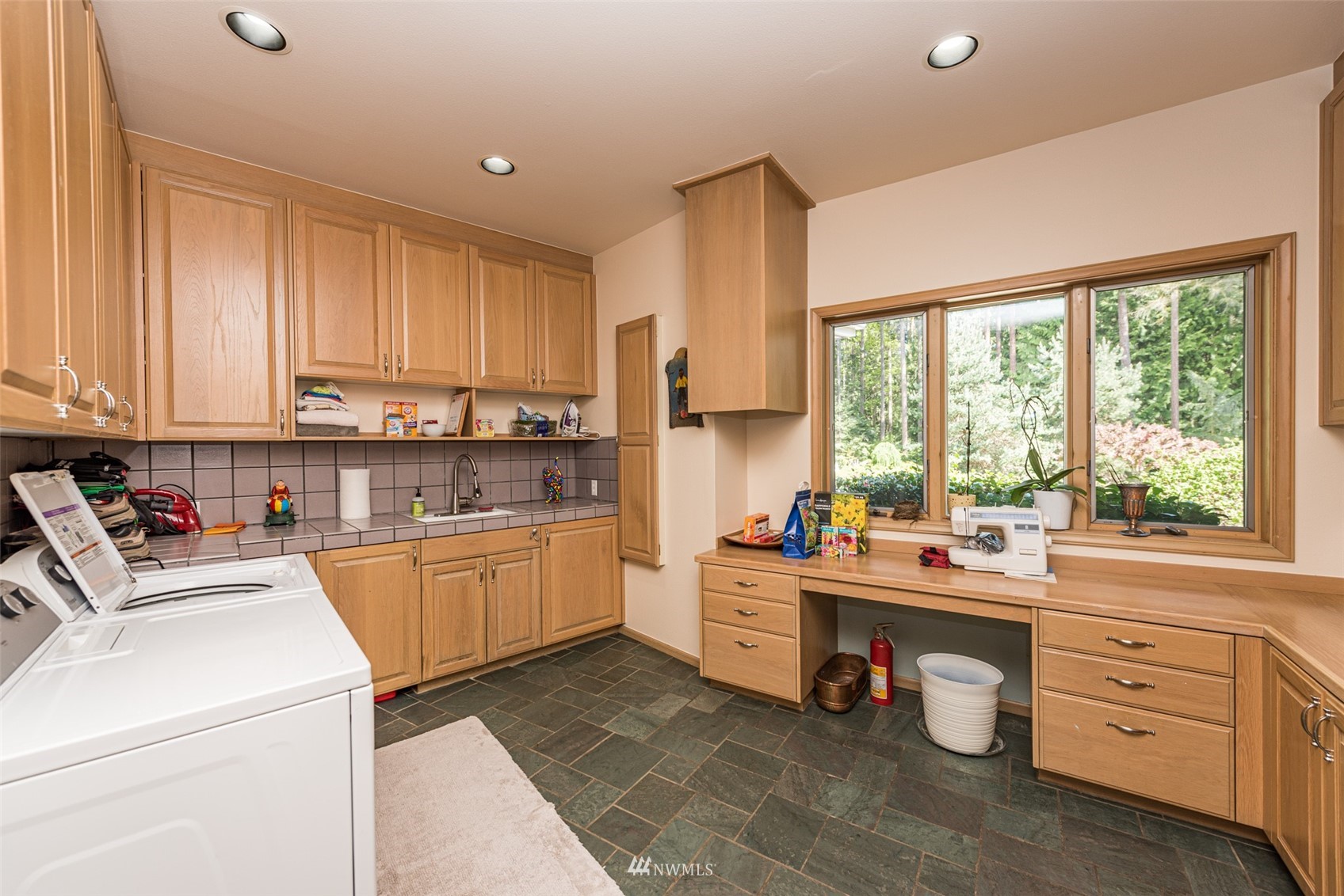 4949 Woodcock Road Sequim, WA 98382 - Photo 29 of 40 a kitchen with a stove a refrigerator and white cabinets