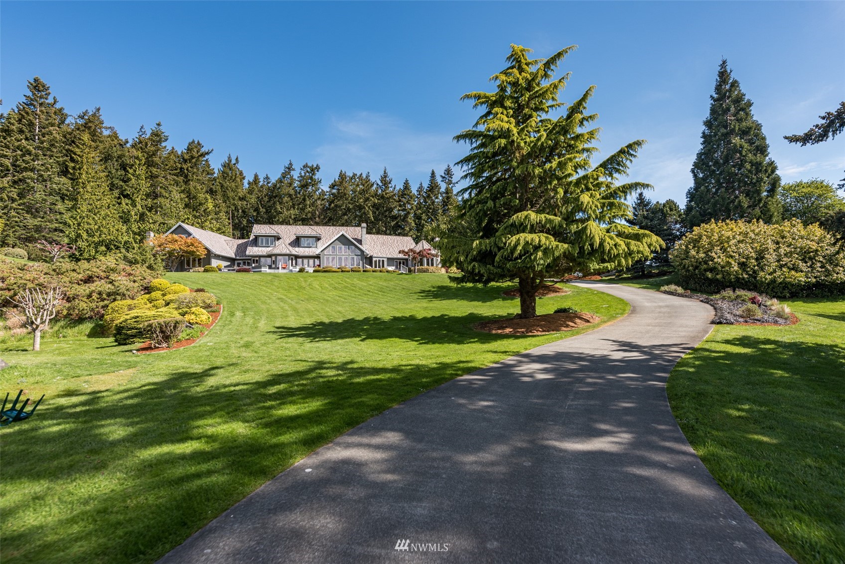 4949 Woodcock Road Sequim, WA 98382 - Photo 3 of 40 a view of a garden with a house in the background