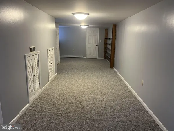 a room with lots of wooden furniture a rug and a window