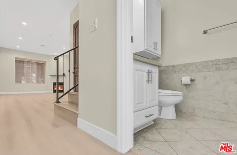 a view of a hallway with wooden floor cabinets and entryway