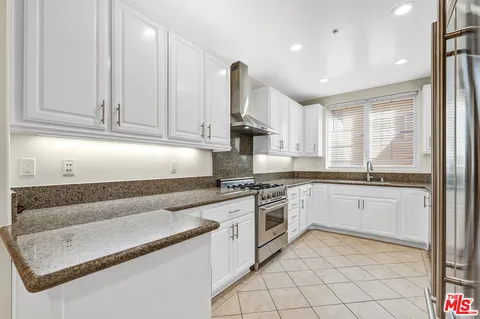 a kitchen with stainless steel appliances granite countertop a stove and a sink