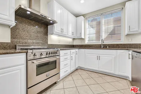 a kitchen with kitchen island granite countertop a stove and a refrigerator