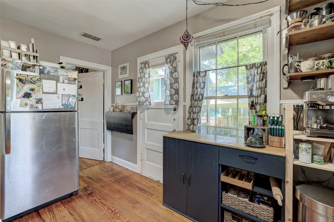 809 East 44th Street Austin, TX 78751 - Photo 14 of 40 Kitchen featuring a wealth of natural light, light wood-type flooring, freestanding refrigerator, visible vents, and open shelves