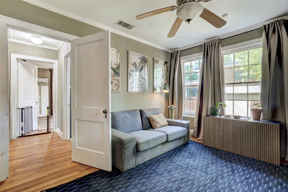 809 East 44th Street Austin, TX 78751 - Photo 19 of 40 Living area with radiator heating unit, wood finished floors, visible vents, and crown molding