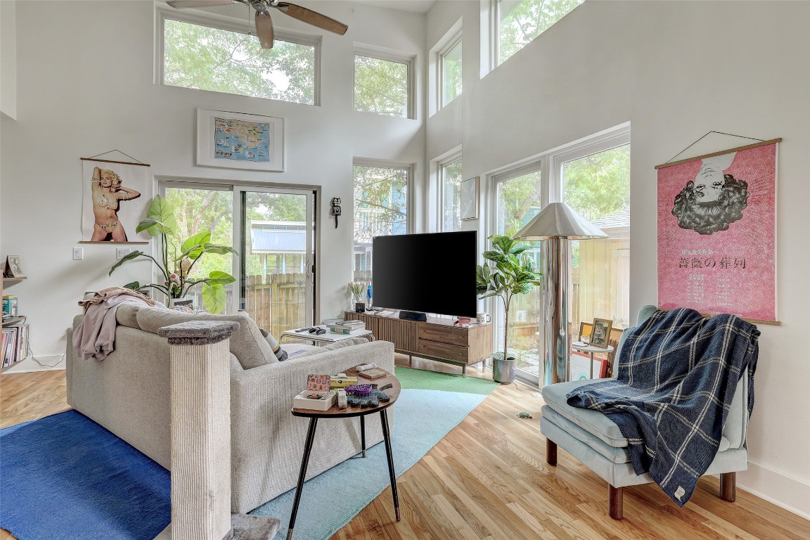 809 East 44th Street Austin, TX 78751 - Photo 29 of 40 Living area with a wealth of natural light, a ceiling fan, wood finished floors, and a towering ceiling