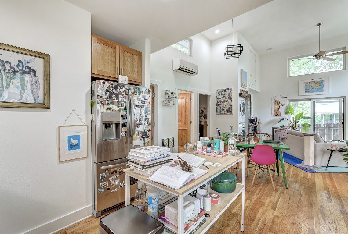 809 East 44th Street Austin, TX 78751 - Photo 39 of 40 Kitchen featuring light wood-style flooring, a towering ceiling, ceiling fan, stainless steel fridge with ice dispenser, and a wall mounted AC