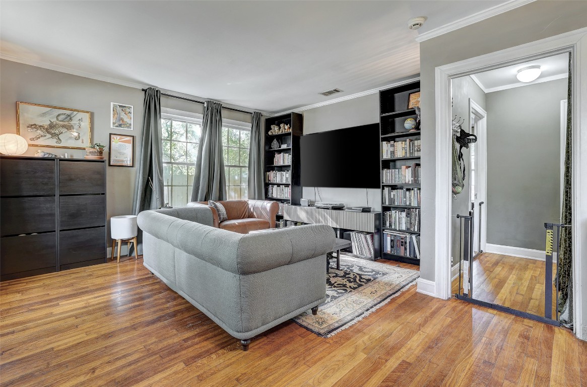 809 East 44th Street Austin, TX 78751 - Photo 5 of 40 Living area featuring built in shelves, ornamental molding, and wood finished floors