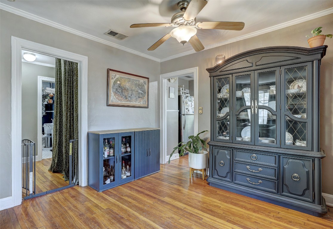 809 East 44th Street Austin, TX 78751 - Photo 9 of 40 Bar with freestanding refrigerator, a ceiling fan, visible vents, and crown molding