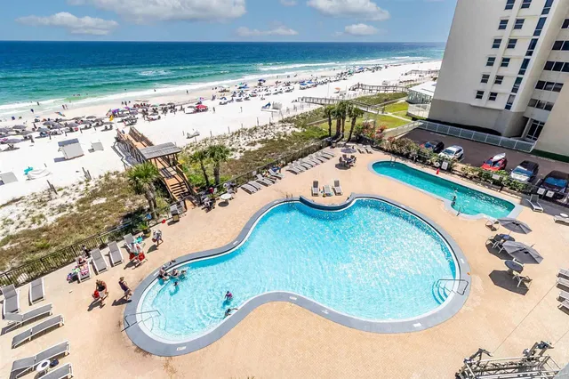a living room with furniture a rug and a floor to ceiling window