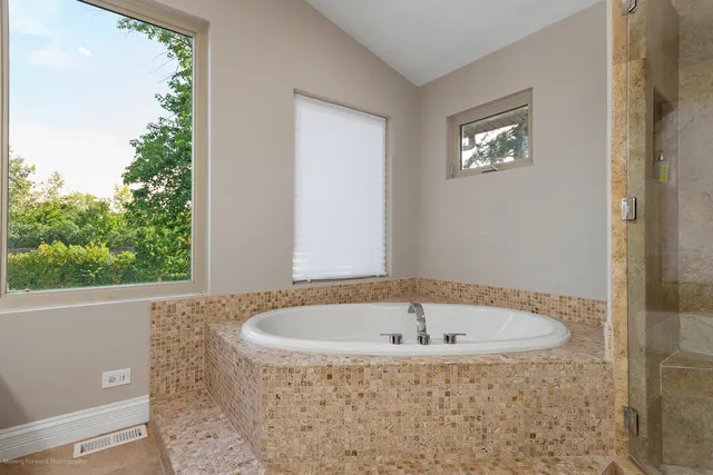 a bathroom with bathtub and window