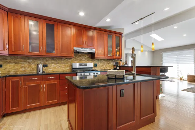 a kitchen with kitchen island granite countertop a sink window and cabinets