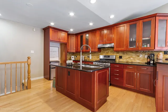 a kitchen with stainless steel appliances granite countertop a stove a sink dishwasher and a refrigerator