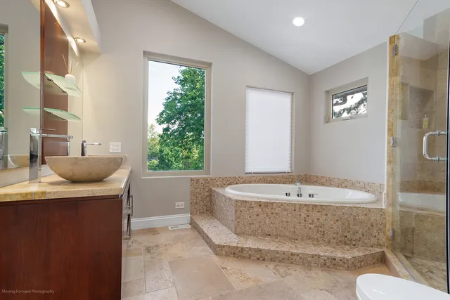 a spacious bathroom with a granite countertop sink and a bathtub